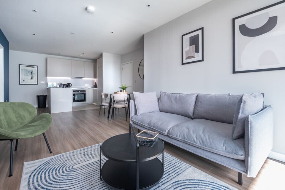 Inviting living room with plush sofa, coffee table and open kitchen behind