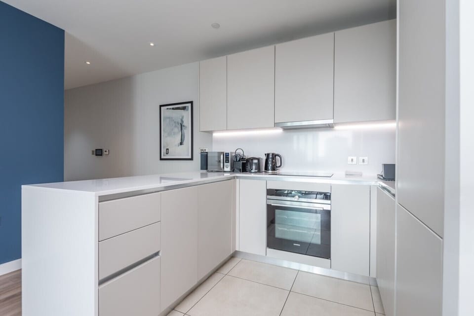 Sleek fully-equipped kitchen with oven, hob and modern white cabinetry
