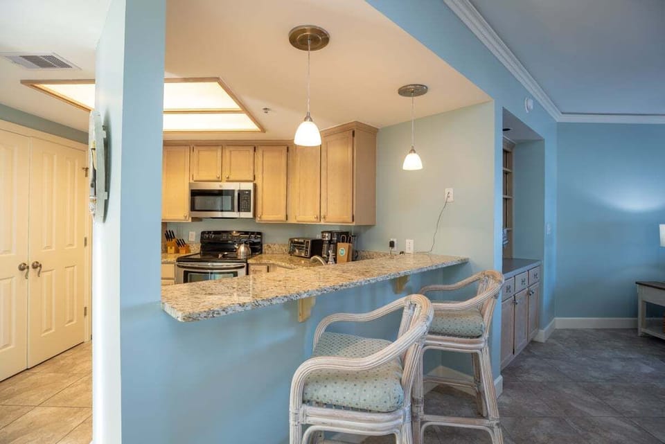 This open kitchen features granite countertops and stainless appliances, with a generous breakfast bar that invites casual meals and easy conversation.