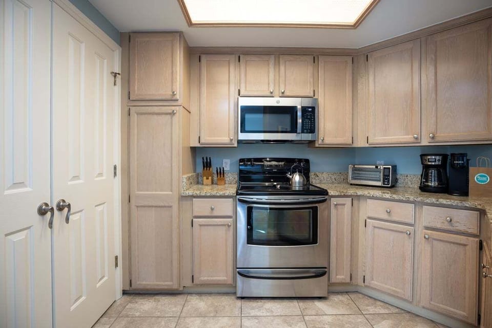 Granite countertops, and stainless appliances create a clean, coastal feel, while the spacious layout flows seamlessly into the dining and living areas.