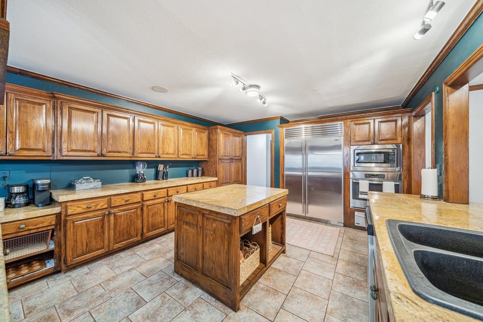 Full kitchen with eat in area, sub zero fridge, food warmer, prep islands, etc