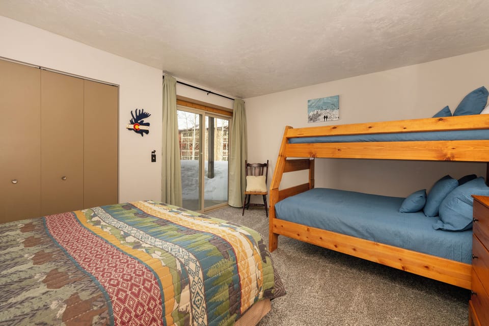 Rest comfortably in your spacious bedroom featuring both a cozy double bed and wooden bunk beds, perfect for families or groups seeking mountain adventure.