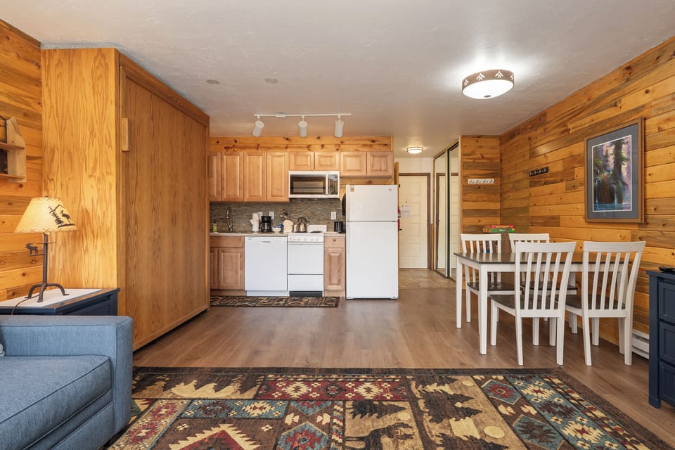 Your cozy cabin retreat at 564 SilverCreek Inn blends rustic charm with modern comfort—warm wood walls, full kitchen, and dining space for memorable meals.