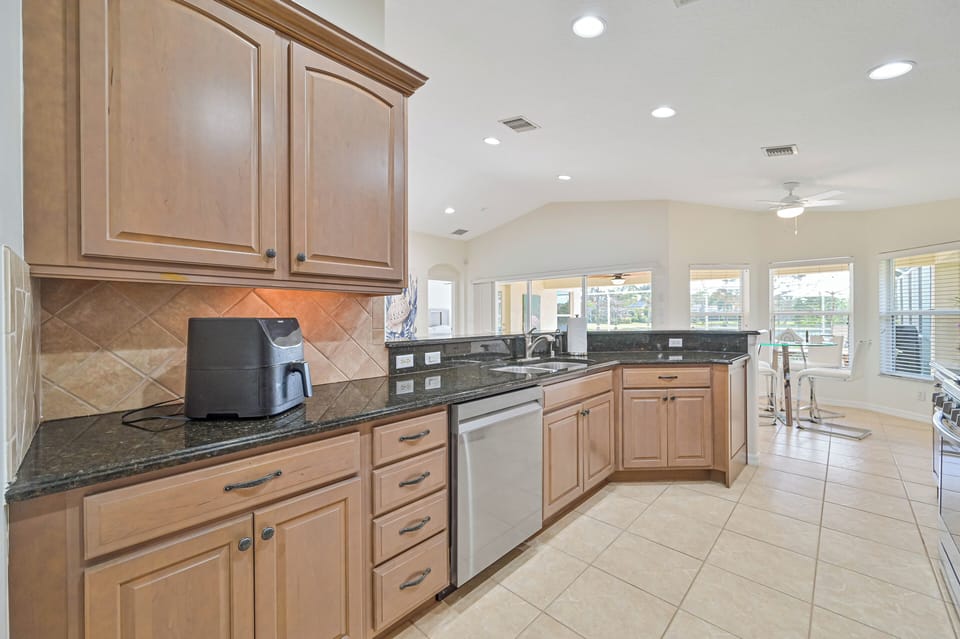 Lake Vista - Fully equipped kitchen with breakfast bar and the breakfast nook offers beautiful pool and lake view