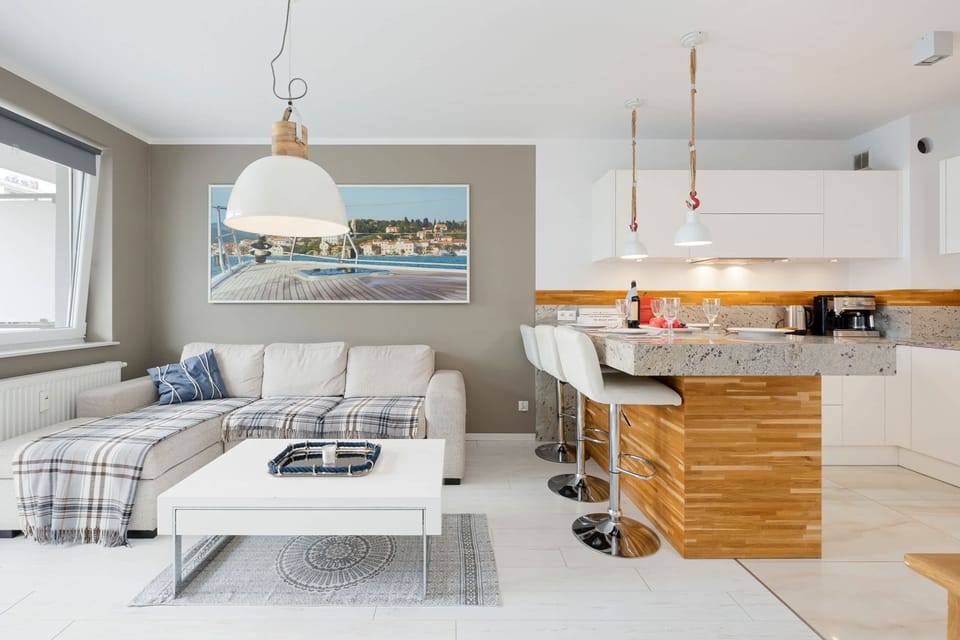 A spacious living area seamlessly connected to a modern kitchen, with elegant furnishings and natural light.