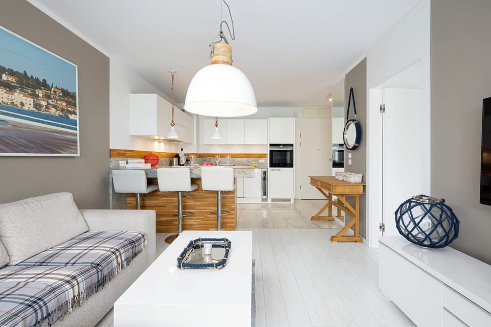 A living area seamlessly connected to a modern kitchen, with elegant furnishings and natural light.
