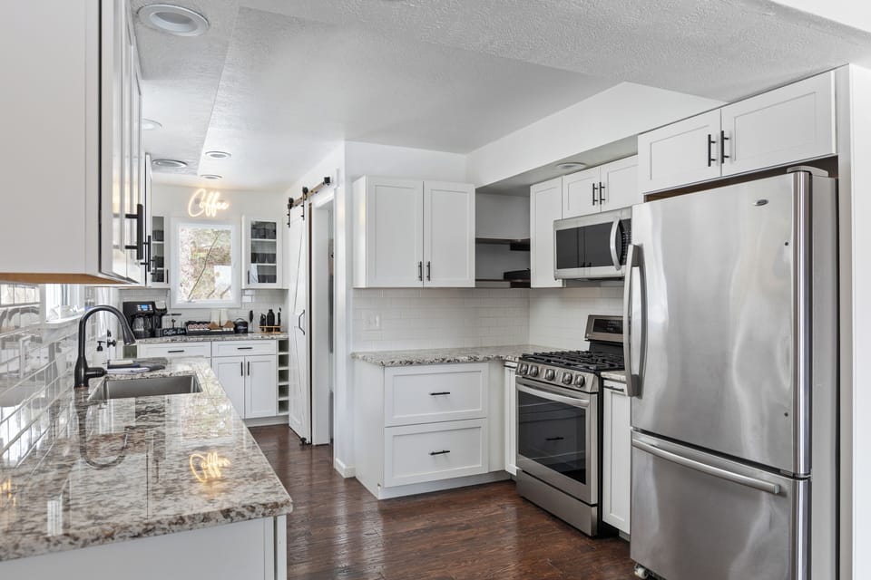 Fully stocked kitchen with stainless steel appliances, coffee bar, and pantry.