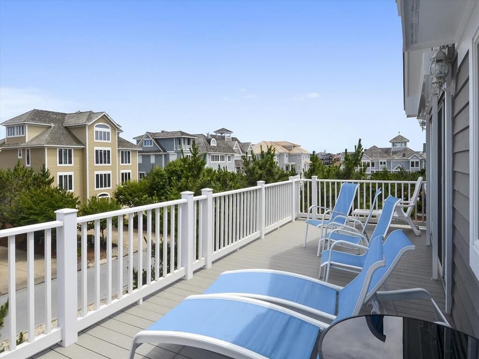 Expansive deck with comfortable lounge chairs, perfect for soaking up the sun while enjoying views of the community and fresh ocean air.