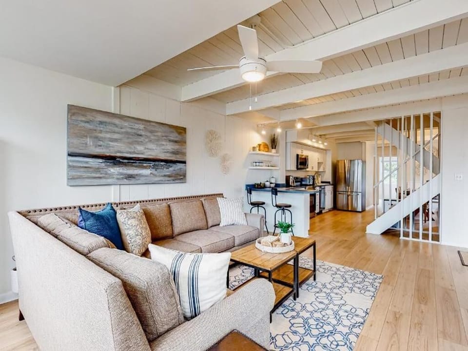 Bright and airy living space with nautical decor, an open-plan layout, and a cozy sectional, ideal for unwinding after a day of beach adventures.