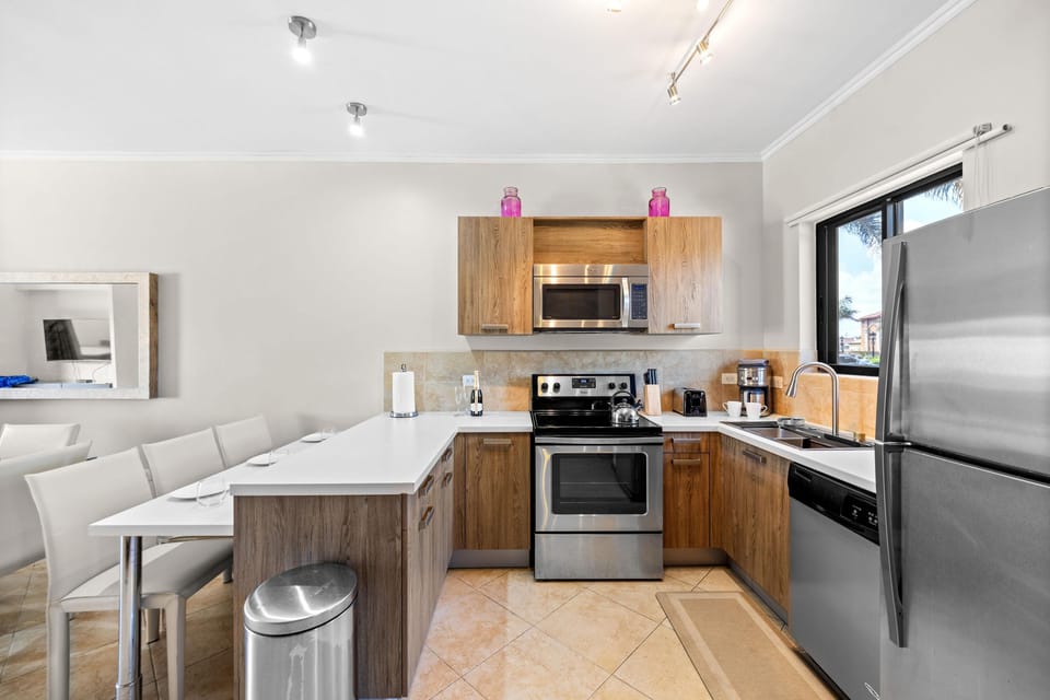 A sleek kitchen with a view, featuring a corner layout and stainless steel appliances.