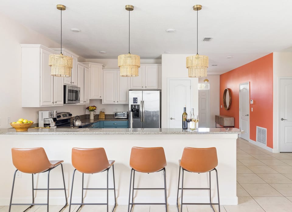 Fully equipped kitchen with island and barstool seating.
