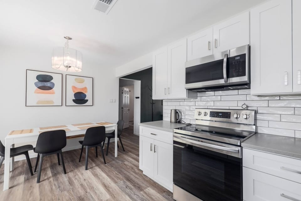 Spacious dining area with a table for four, seamlessly connected to the kitchen on the right, offering a cozy setup for meals and gatherings.