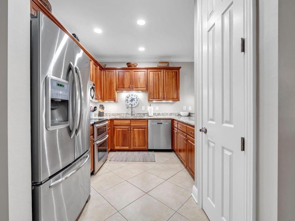 Your fully equipped kitchen features warm wood cabinets, granite counters, and stainless appliances for preparing memorable vacation meals.