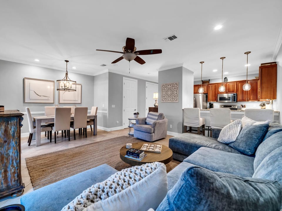 Settle into plush blue sofas in your open-concept haven, where coastal charm meets modern comfort for perfect family gatherings.
