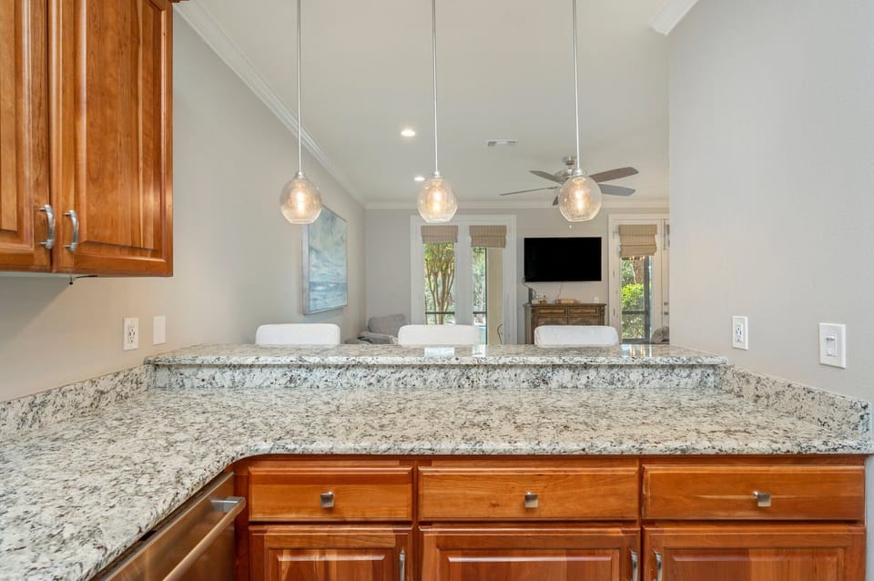 Your spacious kitchen flows seamlessly into the dining area, where pendant lights cast a warm glow over granite counters perfect for morning coffee.