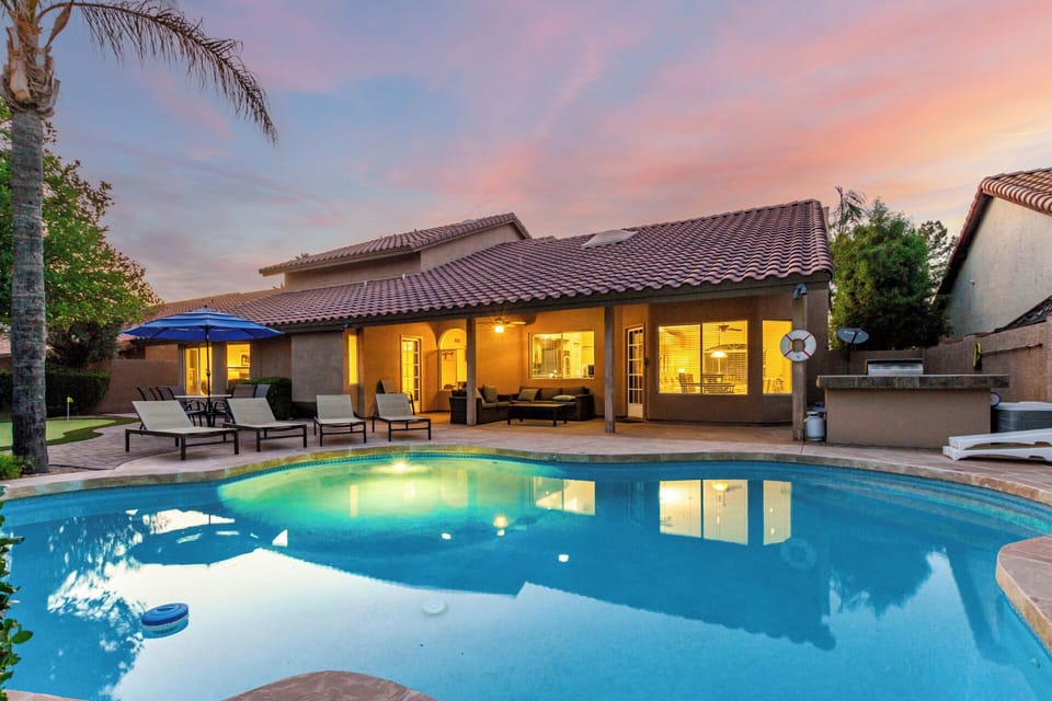 Stunning backyard with pool, shaded loungers & patio—perfect for sunset vibes.