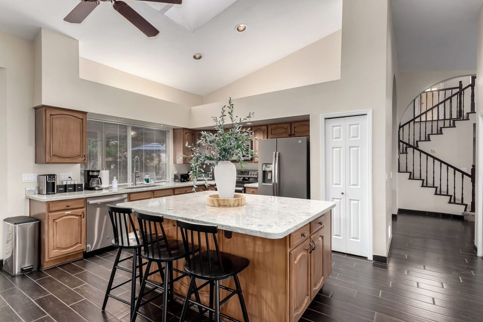 Chef’s kitchen with stainless appliances, island & barstools for casual dining.