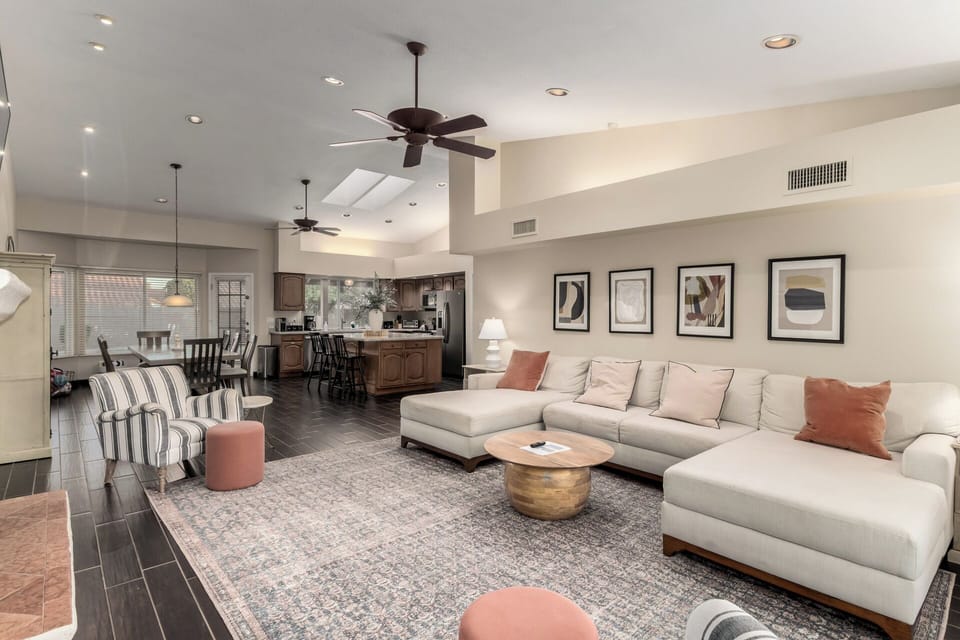 Cozy living room with plush sectional, warm tones & fireplace under Smart TV.