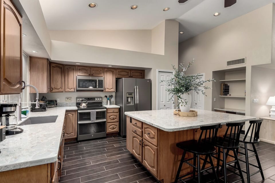 Bright kitchen with granite counters—fully equipped for cooking, baking & coffee