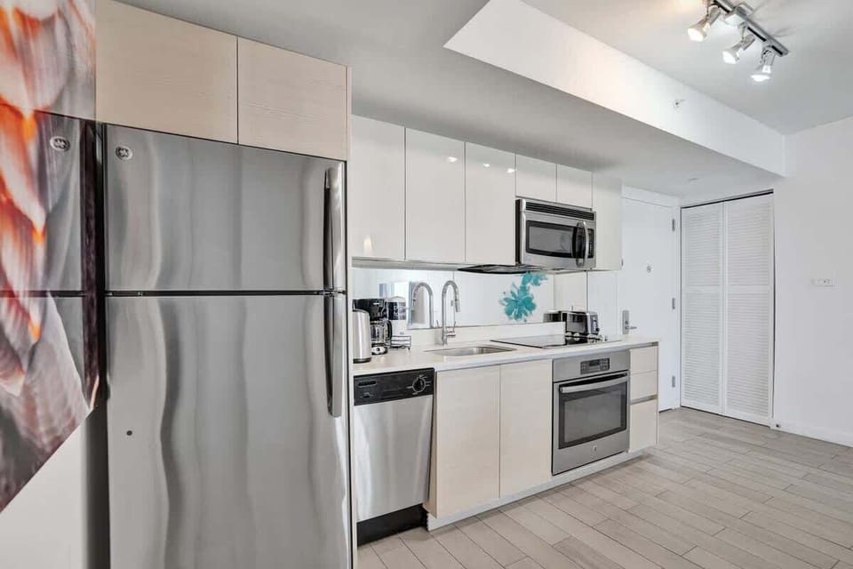 Fully equipped kitchen with stainless steel appliances and dinnerware