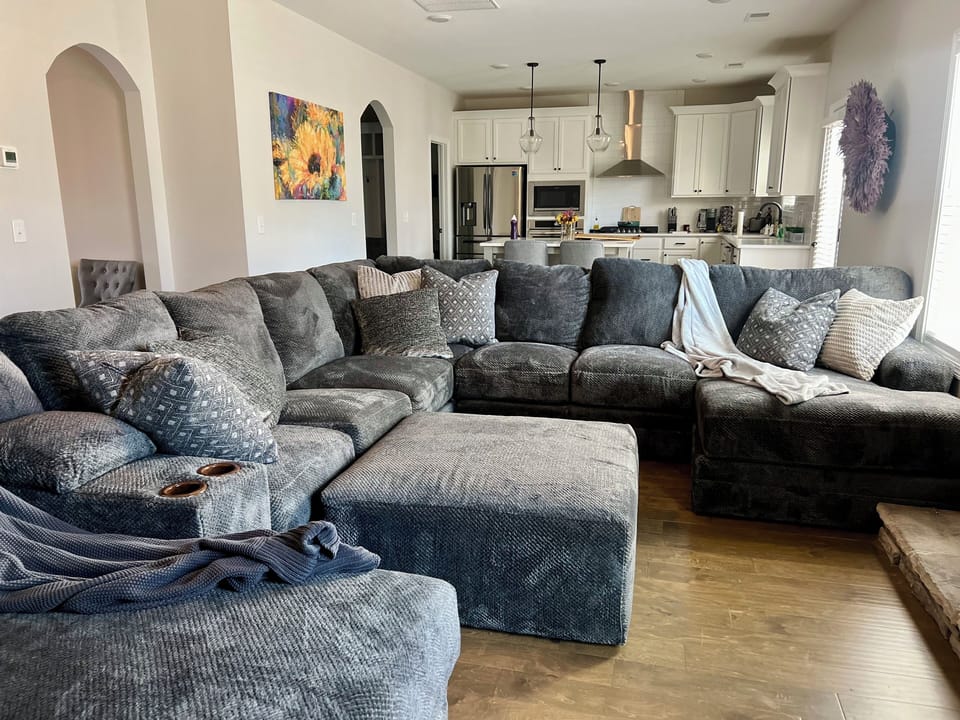Oversized sectional w/ TV mounted on floor to ceiling stone fireplace 