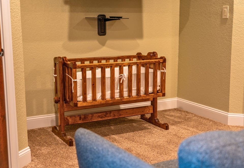 A charming crib setup ensures that even the youngest guests have a comfortable and cozy space to rest and recharge during their stay.