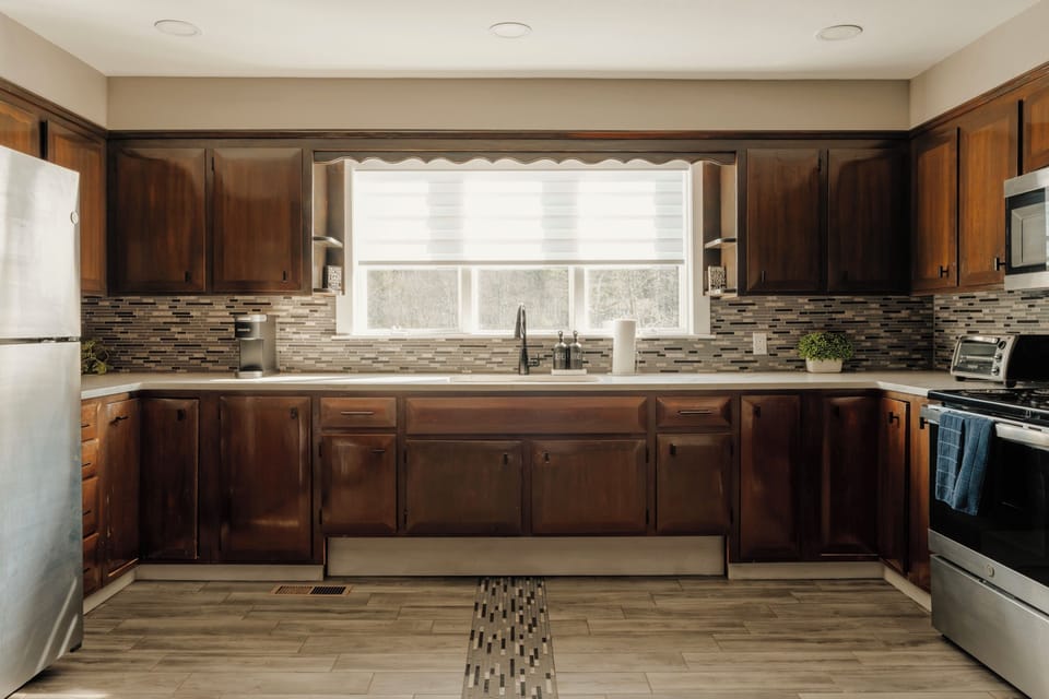 Cook up a meal at this stainless range, backed by a mosaic tile splash and full-size fridge across the room. The window over the sink lets you keep an eye on the yard while you wash up.