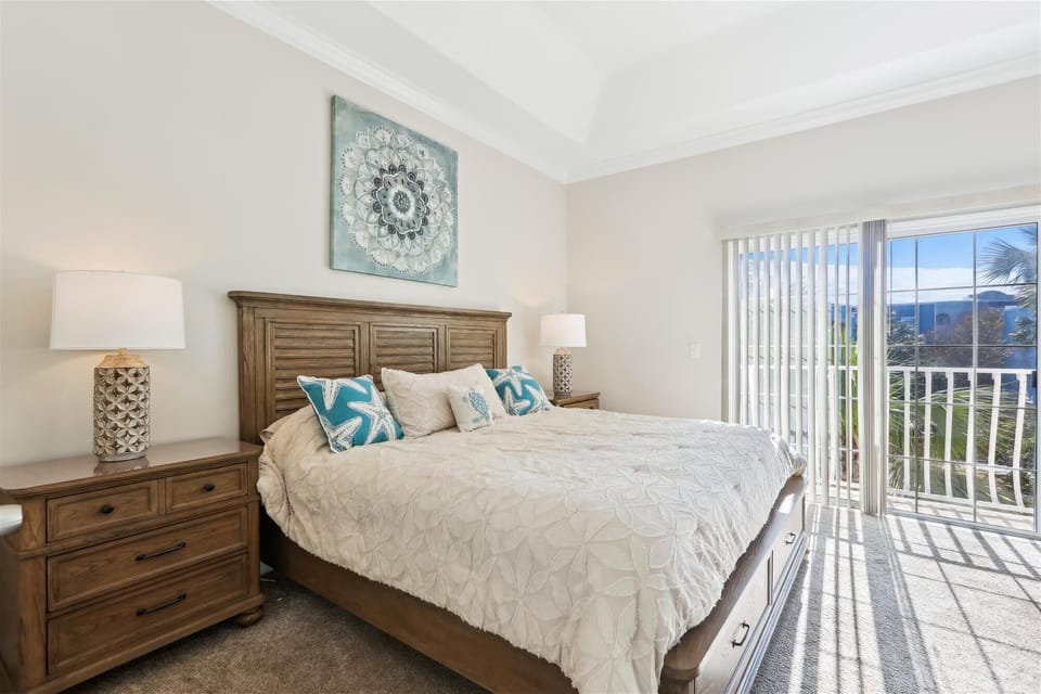 - Master bedroom with king bed nightstands lamps and sliding glass door access  
- Natural light and outdoor views create a bright welcoming retreat for guests  
- Perfect for restful nights during a Florida coastal vacation rental stay  
