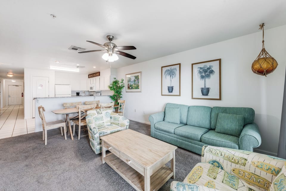Your comfortable living space awaits with coastal décor, ceiling fan comfort, and open kitchen perfect for vacation meals.