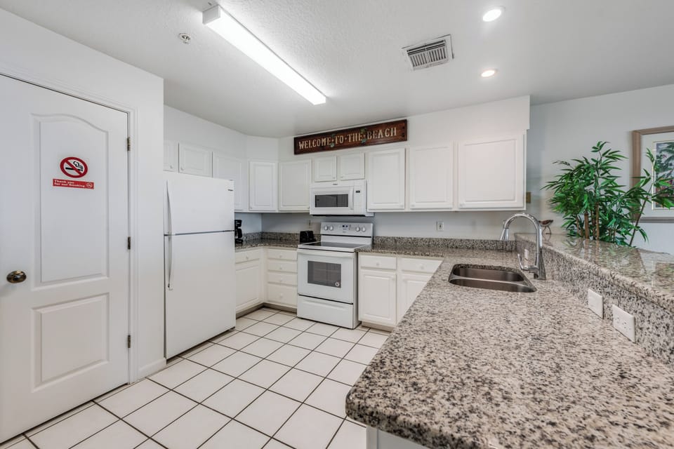Prepare your favorite meals in this fully equipped kitchen with granite countertops and modern appliances.