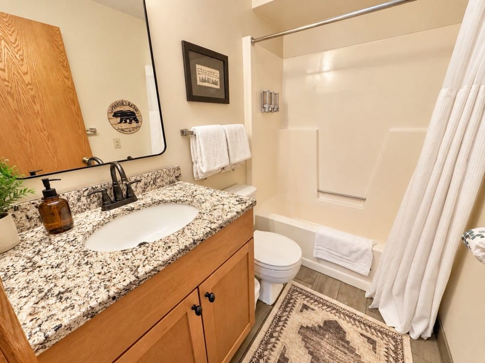 Loft full bathroom stocked with shampoo conditioner body wash and towels