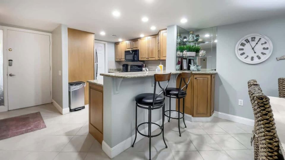 The kitchen opens into the living area via a raised breakfast bar with sleek.