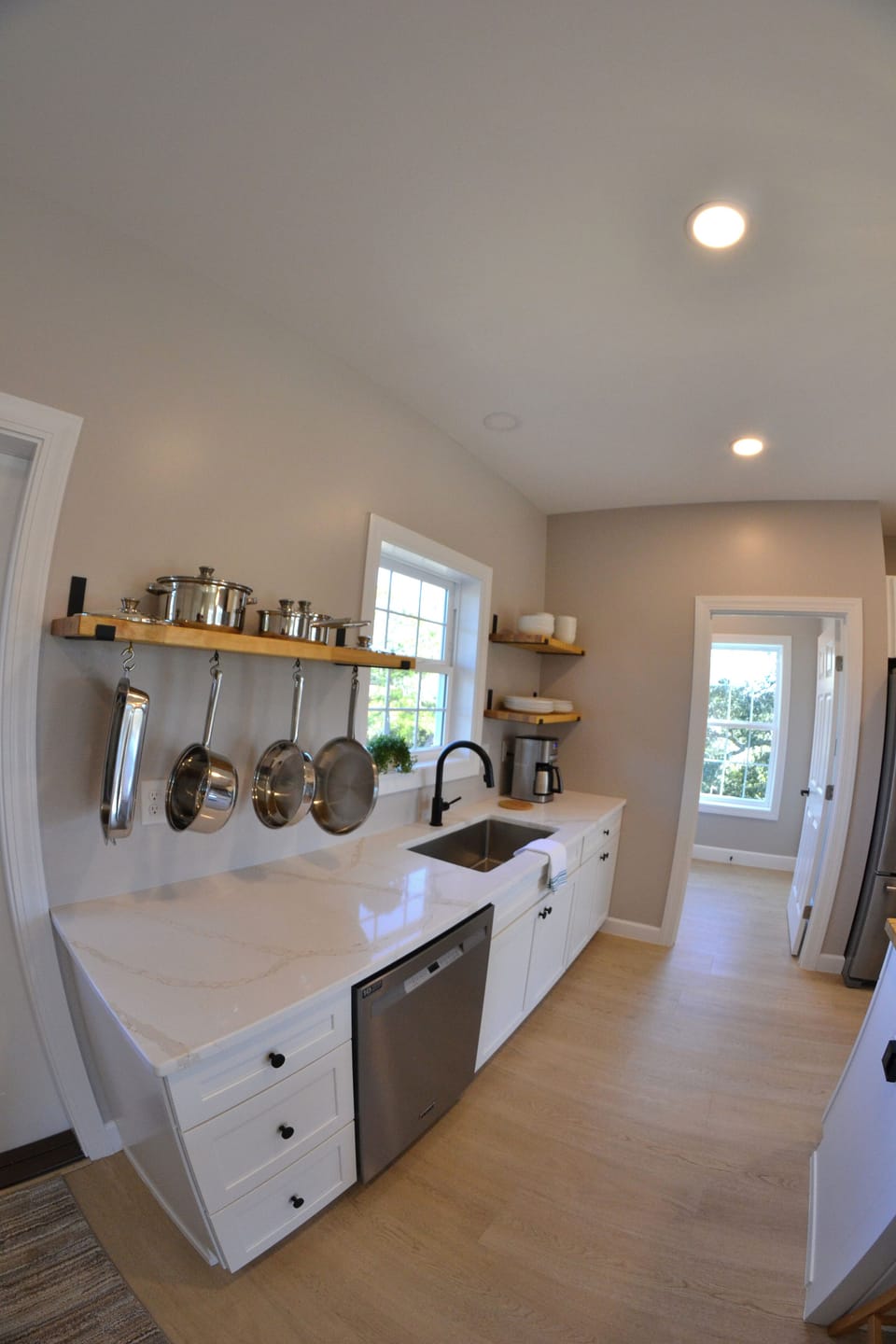 Beautiful quartz counter tops and butcher block open shelves for everyday items