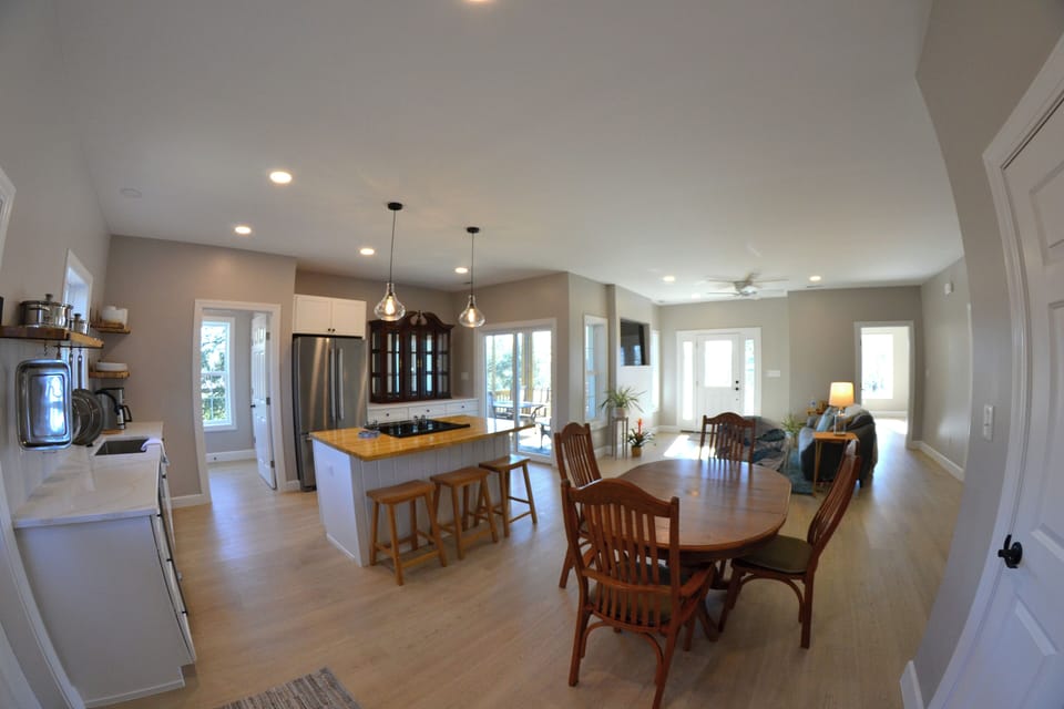 Dining table seats 6 and 3 stools at adjacent island