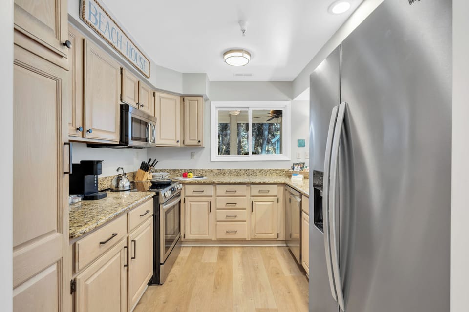 Fully Stocked Kitchen:  Well-equipped with pass-through window to the porch, breakfast bar, and dining area seating for 6.