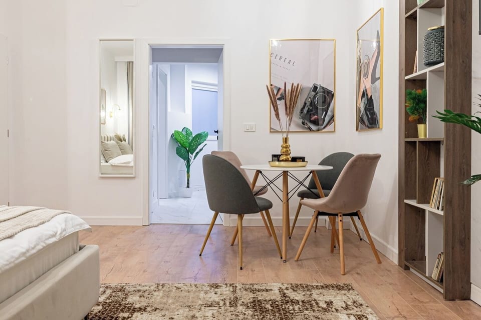 Dining table with chairs for enjoy a delicious dinner, library with books, cozy king size bed, wall paintings, mirros, stylish carpet