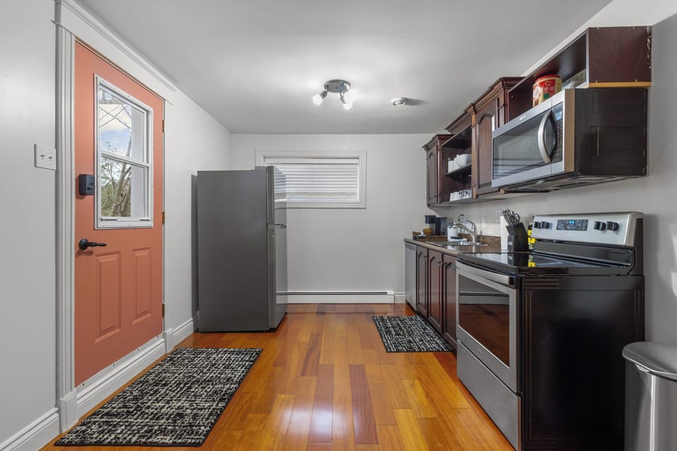 Modern kitchen with stainless steel appliances, dark wood cabinets, and ample counter space. Ideal for preparing delicious meals during your stay.