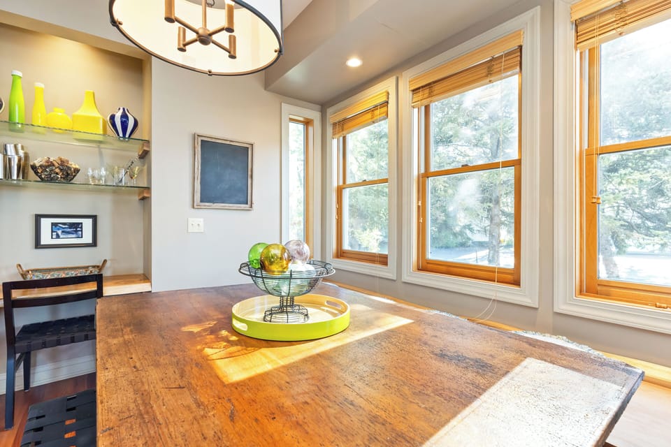 The kitchen table is open to beautiful views of the outdoor surroundings, allowing you to enjoy the scenery while dining.