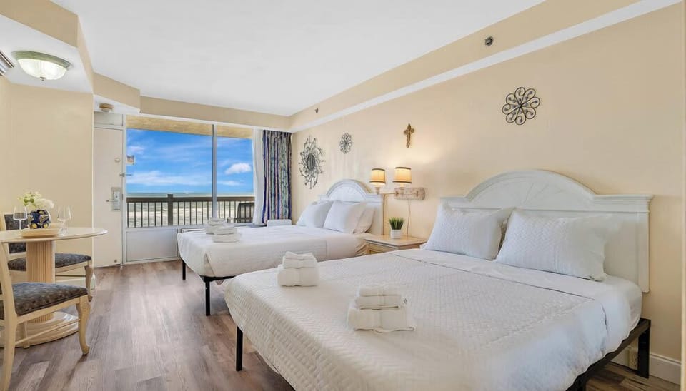 Relax in this bright oceanfront room with two queen beds and a balcony view.
