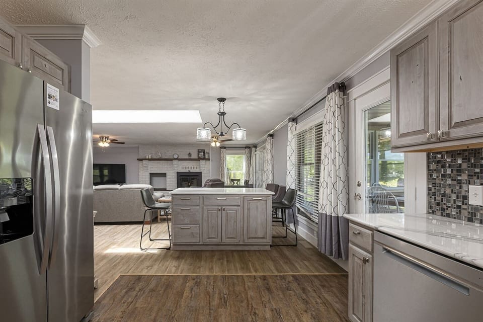 Modern kitchen with stainless steel appliances and wooden floors.