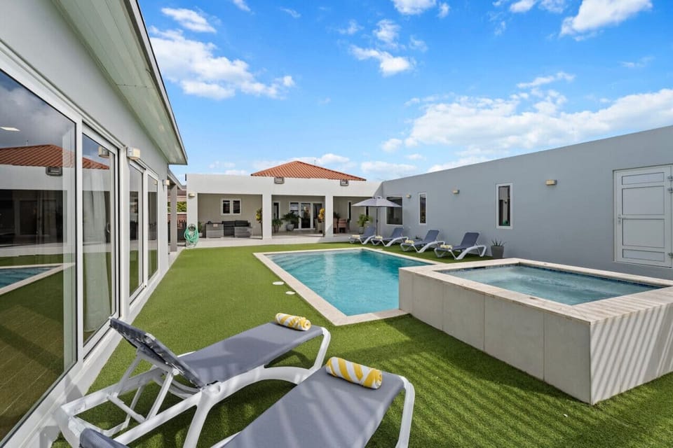 Dive into relaxation in the private pool, surrounded by comfortable sun loungers for soaking up the Aruban sun.