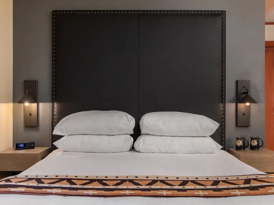 A cozy, inviting space featuring a plush bed and soft lighting, creating the perfect spot for relaxation and unwinding.