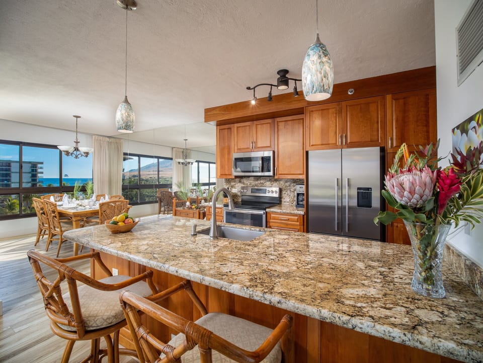 Enjoy a fully equipped gourmet kitchen with granite countertops and ocean views, ideal for cooking and dining in paradise.
