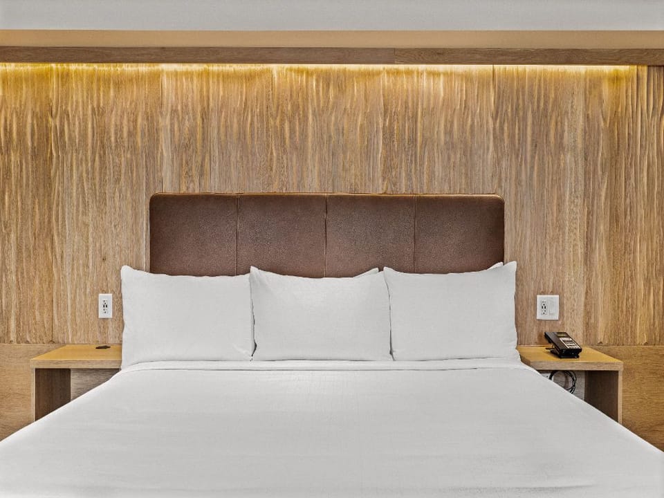 A serene bedroom with warm lighting and a plush bed, offering a restful and inviting atmosphere for a perfect night's sleep.