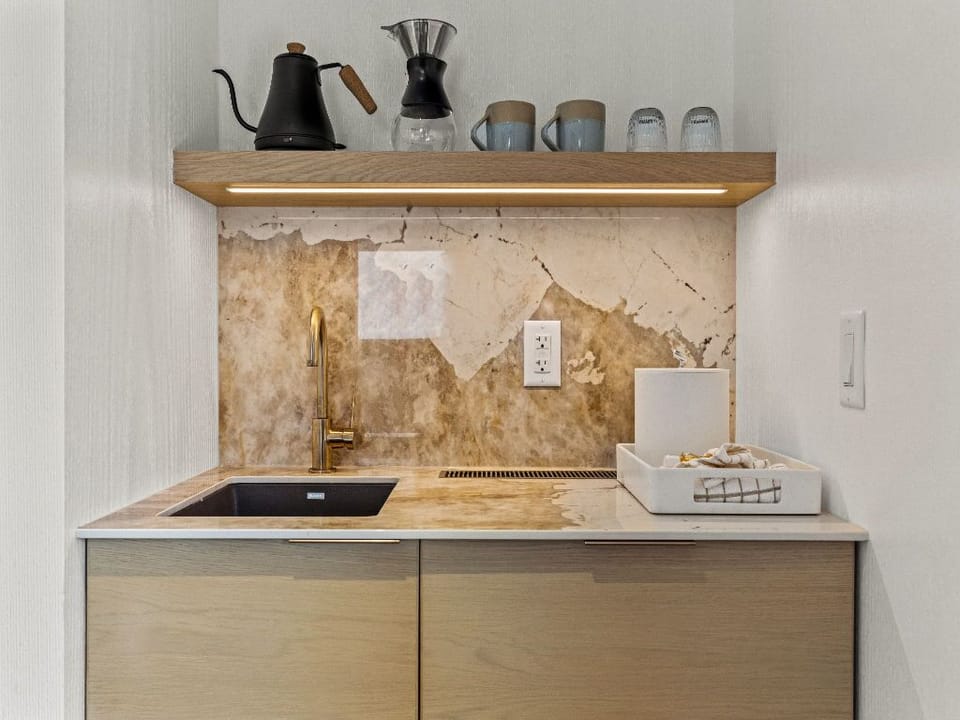 A compact and stylish kitchenette featuring modern finishes, ideal for preparing light meals in a cozy environment.