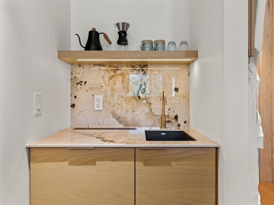 A thoughtfully designed kitchenette with natural textures and a practical layout, blending style and functionality seamlessly.