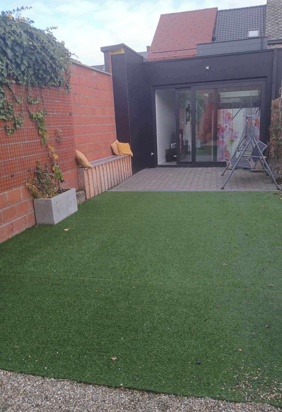 Terras en tuin met fietsenberging.