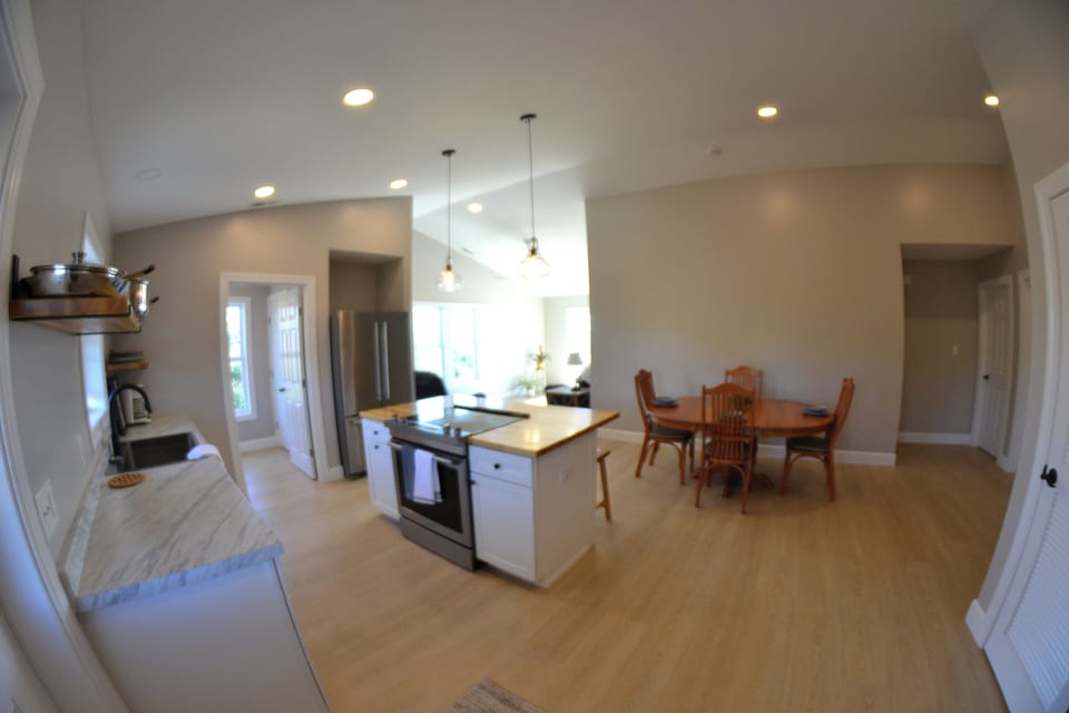 Open concept kitchen with dishwasher, fridge, & butcher block island with stove