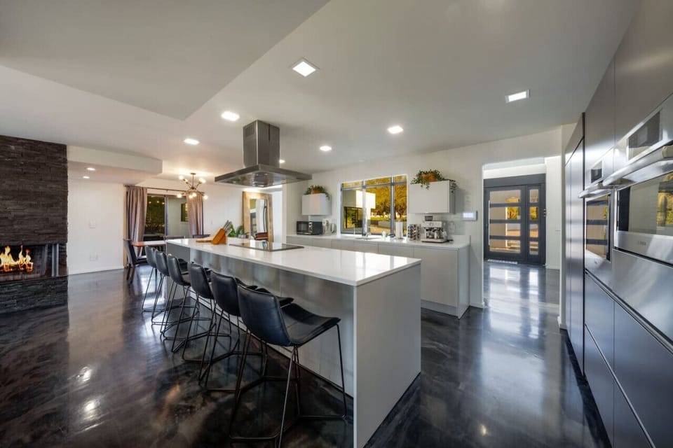 Main House: Open floor plan`s living room leads into a fully-equipped kitchen with plenty of seating for all at the island