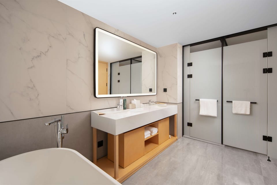 Deluxe Suite, 1 King Bed | Bathroom | Shower, rainfall showerhead, slippers, towels